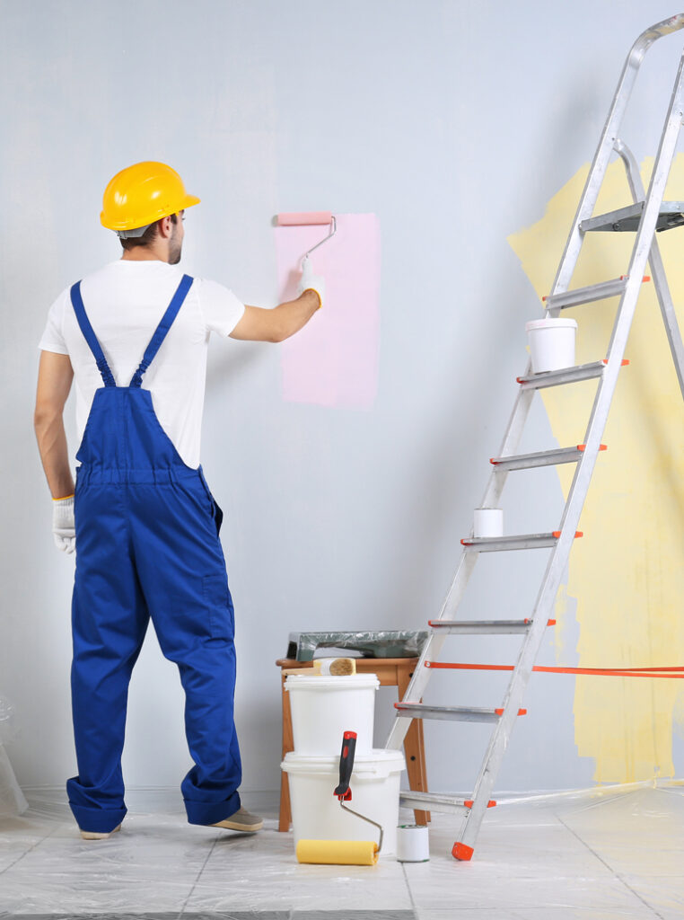 Professional house painter applying pastel color on wall in Oshawa