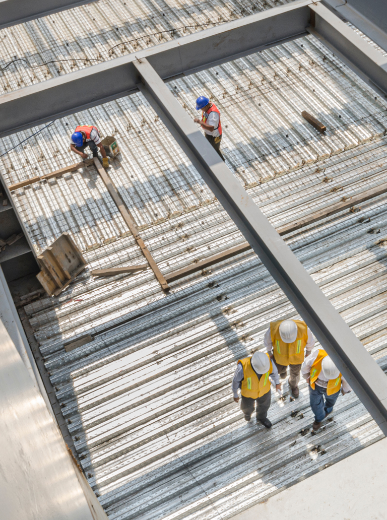 Construction workers preparing steel structure for industrial painting and coating
