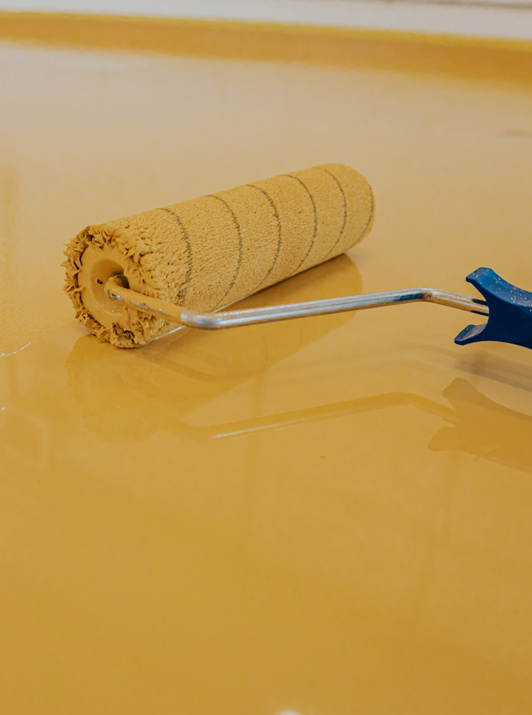 Yellow epoxy floor coating applied with roller
