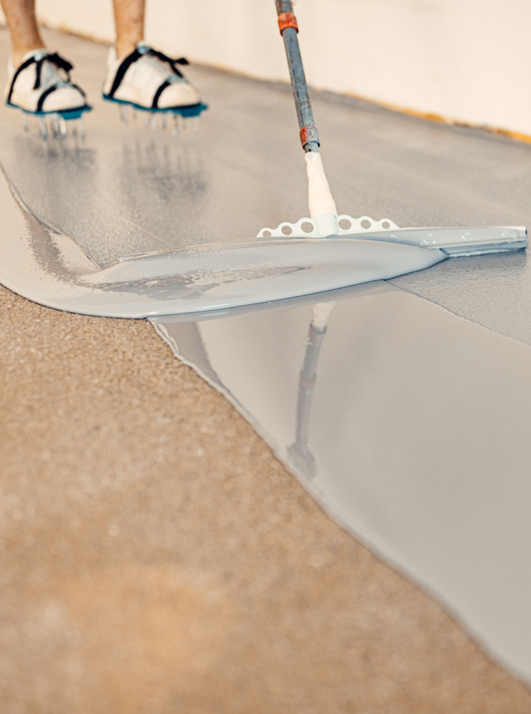 Applying self-leveling epoxy coating on concrete floor