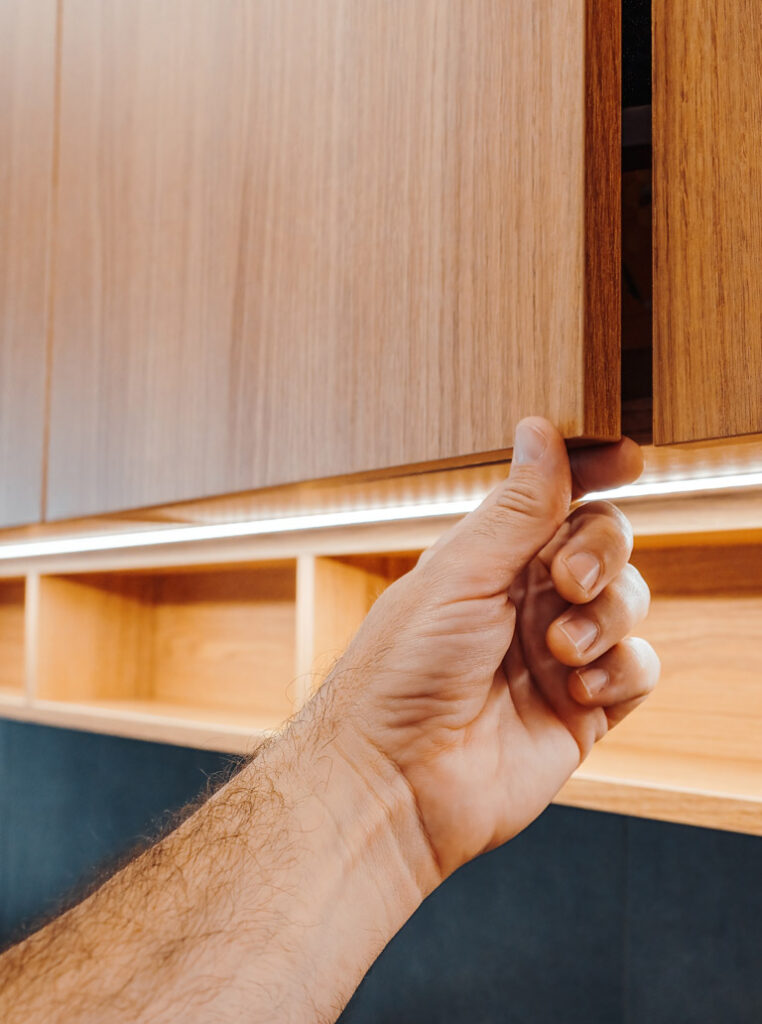 Hand opening newly painted kitchen cabinet in Hamilton