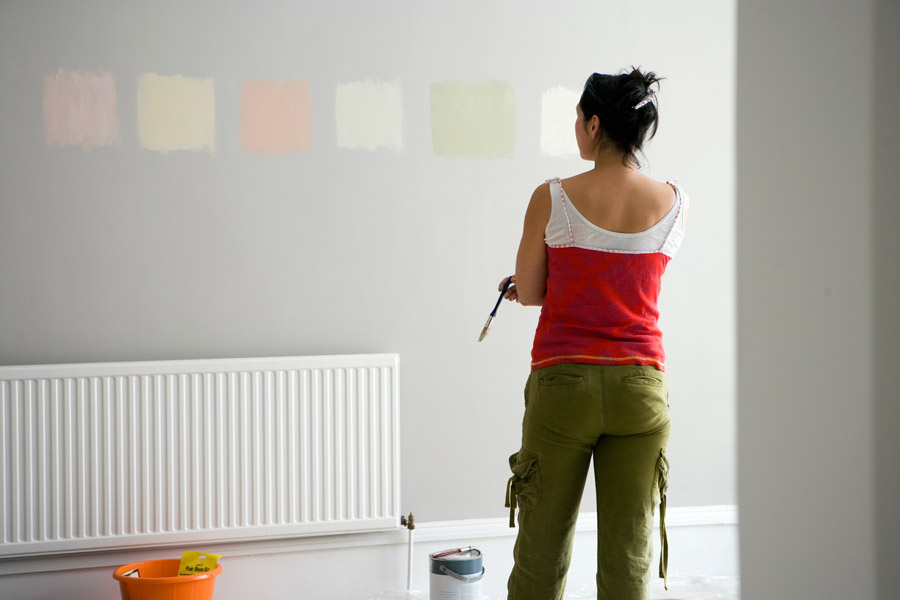 Woman testing wall paint colors during home color consultation session