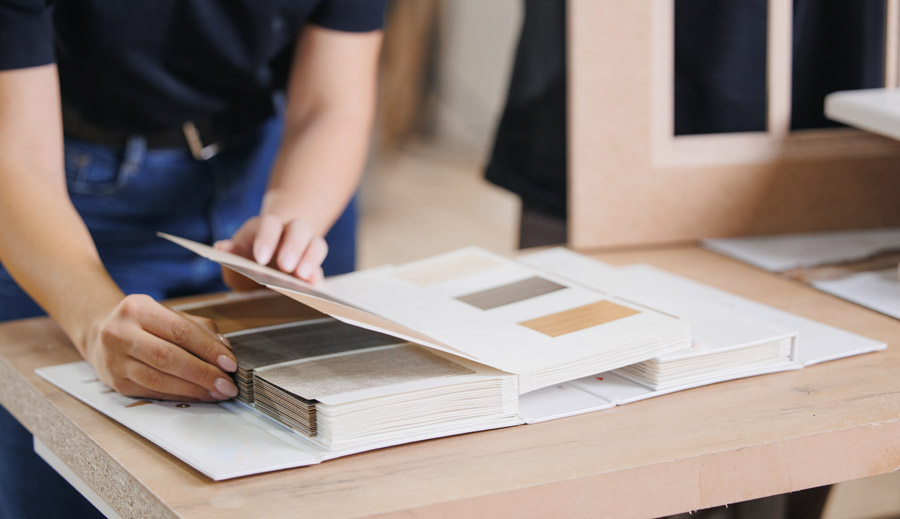 Designer reviewing material and color samples for interior wall and furniture finishes during color consultation