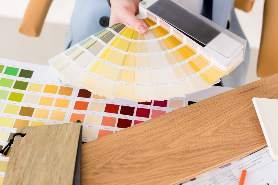 Interior designer choosing wall paint colors using a fan deck of color swatches during color consultation