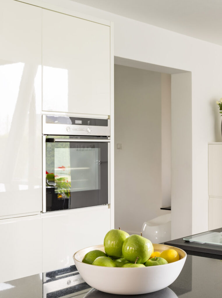 Modern high-gloss white kitchen cabinets after refinishing in Hamilton