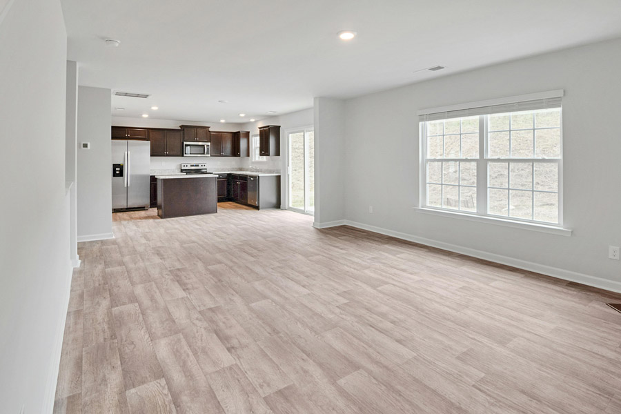 New construction home interior painting Toronto — freshly painted living room and kitchen with white walls and dark wood cabinets