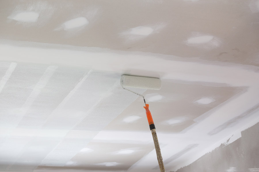 Smooth ceiling after popcorn ceiling removal being painted with roller during renovation in Toronto