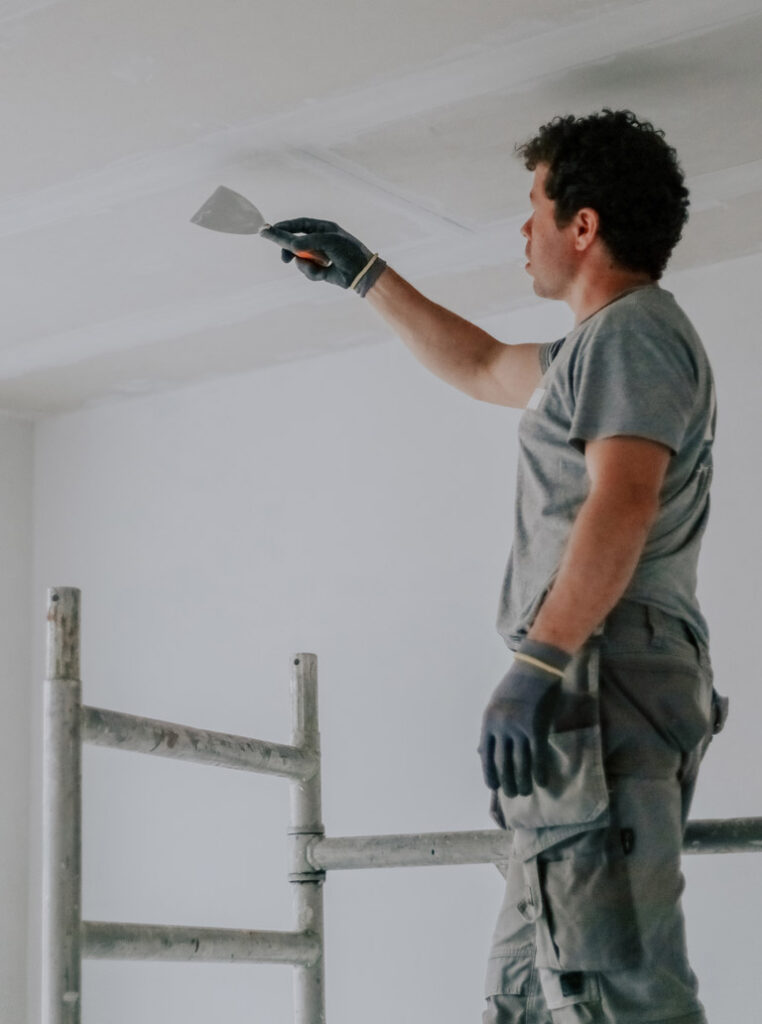 Professional removing popcorn ceiling texture in Toronto home renovation